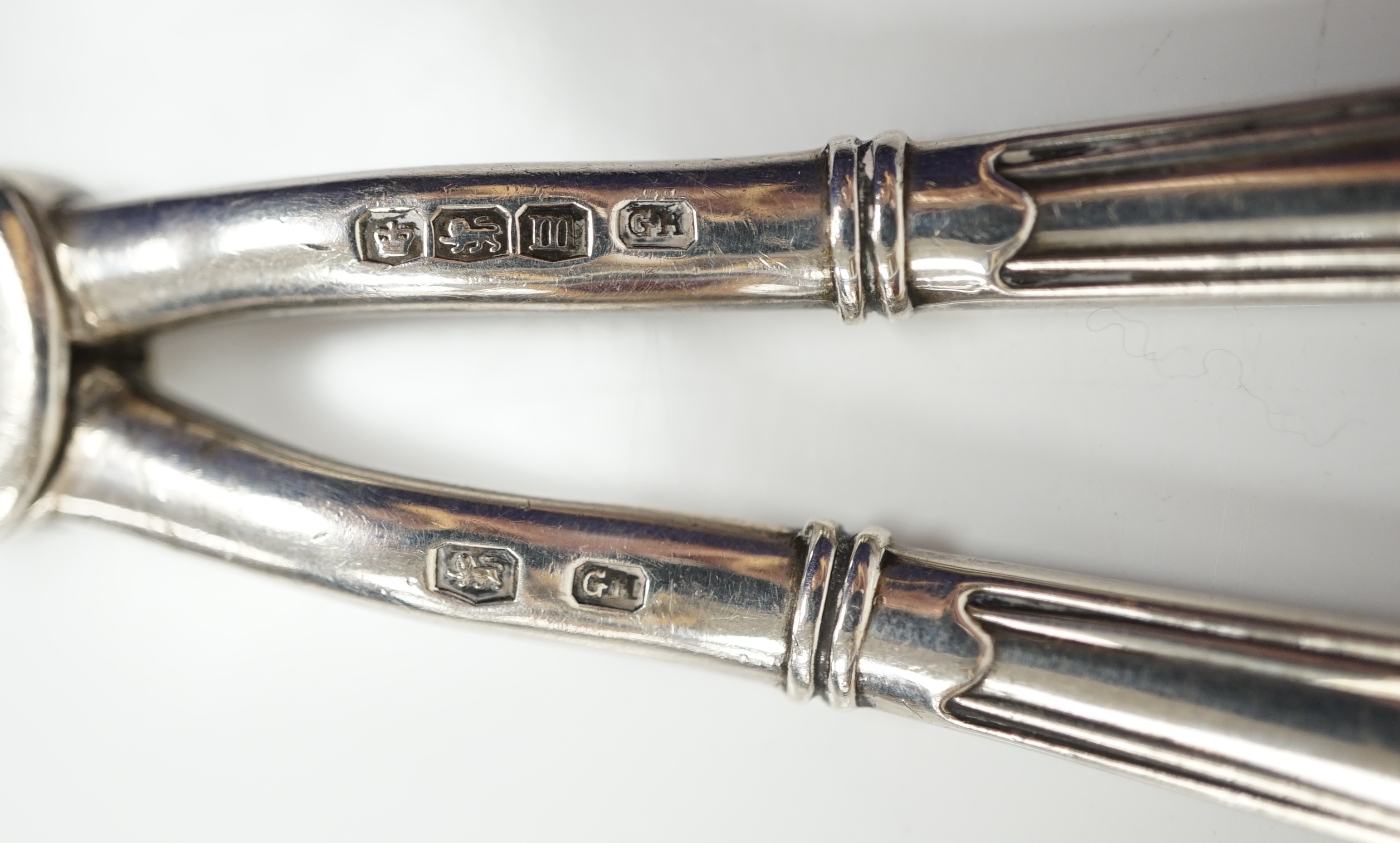 A pair of George V silver grape scissors, Sheffield, 1929, 18.6cm, together with a mother of pearl handled silver butter knife ad a pair of Georgian silver sugar tongs by Peter & Ann Bateman. Condition - poor to fair